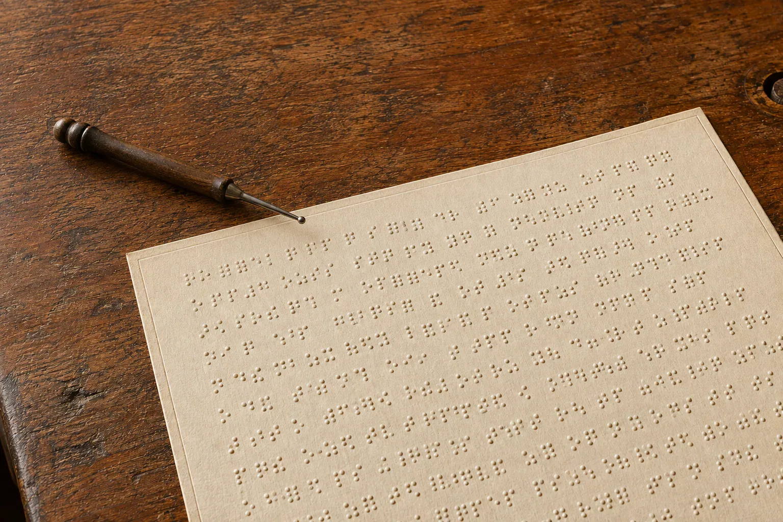 Évocation illustrée d’une feuille à points en relief et d’un poinçon. · رسم تعبيري لورقة ذات نقاط بارزة ومِخرز للكتابة.